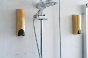 a shower with a shower head on a wall at Eleventh Floor apartment Milano in Cinisello Balsamo +15 photos