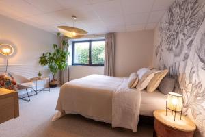 a bedroom with a large white bed and a window at Terrier Ovifat - Nature Jacuzzi & Sauna in Ovifat +55 photos