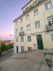 a large white building with a green door at Descubra Lisboa - Príncipe Real in Lisbon