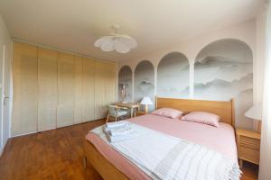 una camera da letto con un letto grande e un tavolo di Art de Recevoir - Prestige & Vue Panoramique sur Saône - Parking Privé T3 Appartement Climatisé a Fontaines-sur-Saône