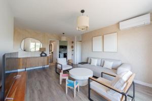 un soggiorno con un divano e un tavolo di Art de Recevoir - Prestige & Vue Panoramique sur Saône - Parking Privé T3 Appartement Climatisé a Fontaines-sur-Saône