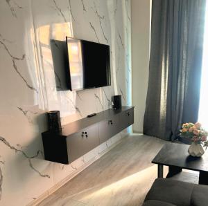 a living room with a television on a wall at Apartment tsaghkadzor SHINE HOME in Tsaghkadzor