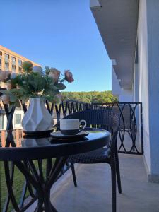 a table with a vase of flowers on a balcony at Apartment tsaghkadzor SHINE HOME in Tsaghkadzor