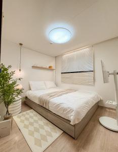 a bedroom with a large bed and a window at Gangdong Station 10-minute walk Cozy Sweet Stay in Seoul