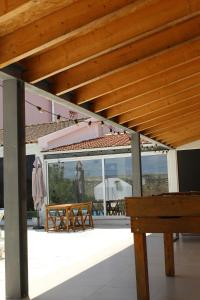 a patio with a wooden roof and a wooden bench at Casa do Caseiro, São Silvestre in São Silvestre