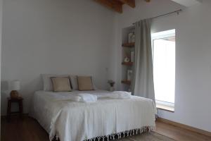 a bedroom with a bed with white sheets and a window at Casa do Caseiro, São Silvestre in São Silvestre +22 photos