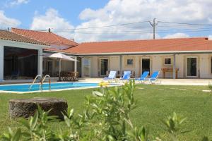 a villa with a swimming pool and blue lounge chairs at Casa do Caseiro, São Silvestre in São Silvestre