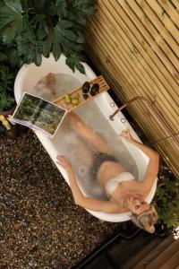 a woman in a bath tub with a magazine at The Lodge Burniston in Scarborough