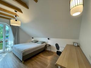 une chambre avec un lit et une table en bois dans l'établissement Alpennelke family apartments, à Bohinjska Bela