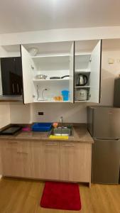 a kitchen with a sink and a refrigerator at Honey's Staycation in Davao City