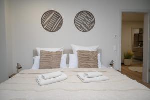 un grand lit blanc avec deux oreillers dessus dans l'établissement Stilvolle & ruhige Ferienwohnung mit Terrasse & Garten, à Petershagen