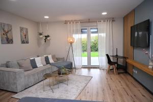 un salon avec un canapé et une table dans l'établissement Stilvolle & ruhige Ferienwohnung mit Terrasse & Garten, à Petershagen