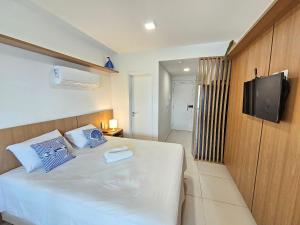 a bedroom with a white bed with a tv on the wall at Açores Praia de Tamandaré - À Beira-Mar in Praia dos Carneiros +217 photos