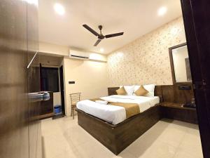 Un dormitorio con una cama y un ventilador de techo. en Hotel City Airr - BUDGET HOTEL, en Pune