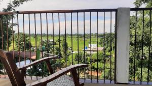 a balcony with a bench and a view of a field at Peace Abode Vista in Dibrugarh