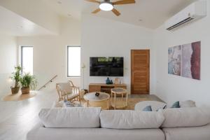 a living room with a white couch and a tv at New Luxury 4BR Villa with Seaview in Haad Chao Phao