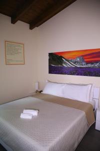 a bedroom with a large bed with two towels on it at Casa Vacanze Galileo in San Gregorio