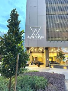 a tree in front of a building with a akron sign at Axon Residence Bukit Bintang By Family Sweet in Kuala Lumpur