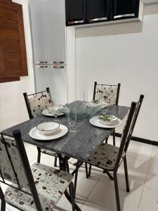 a dining room table and chairs with plates and wine glasses at Casa Viturino in Tailandia