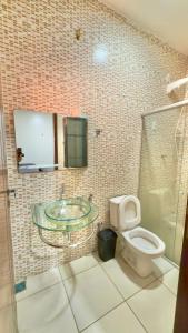 a bathroom with a glass sink and a toilet at VIP eventos in Juazeiro do Norte
