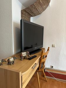 a television sitting on top of a wooden desk at Linde Hotel in Trossingen