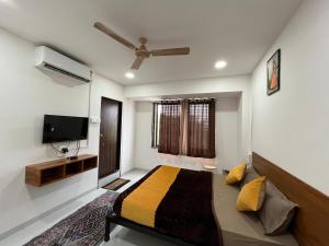 a bedroom with a bed and a flat screen tv at Hotel Bhakti Pride Panchvati Nashik in Nashik