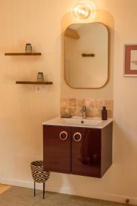 un bagno con lavandino e specchio di Villa Caormina a Prayssac
