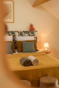 una camera da letto con un letto con asciugamani sopra di Villa Caormina a Prayssac Altre 8 foto