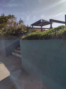 a concrete retaining wall with stairs and a gazebo at San Clemente in San Clemente del Tuyú