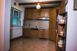 a kitchen with wooden cabinets and a tile floor at Casa Adriana in Ileni