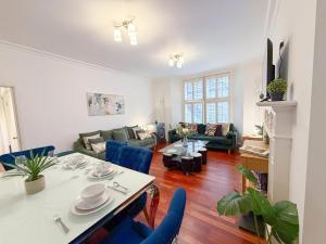 a living room with a table and blue chairs at Modern 3-Bedroom Baker Street flat near Mayfair, Oxford Street & West End in London