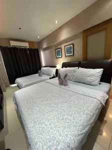 Giường trong phòng chung tại Staycation Near Mall of Asia