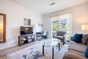 a living room with a couch and a tv at Modern Apt Downtown Walk to Restaurants in Stamford