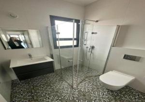 バト・ヤムにあるOַ&O Group- Luxury Tower 3BR Beach View High Floorのシャワー、トイレ、洗面台を備えたバスルーム