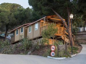 una gran casa de madera al lado de una carretera en Càmping Kanguro, en Sant Pol de Mar