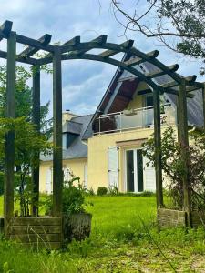 a wooden pergola in front of a house at Foxgloves in La Motte +6 photos