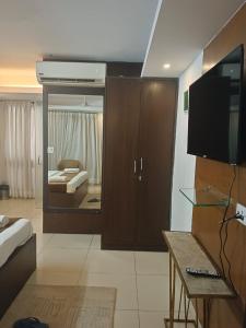 Habitación con cama y TV. en Blueberry Residency, en Nueva Delhi