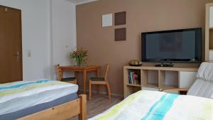 a bedroom with a tv and a bed and a table at BF-Living in Greppin