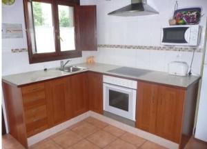 a small kitchen with a sink and a microwave at La Casuca de Remin in Arredondo +9 photos