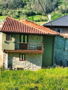 a house with a deck on the side of it at La Casuca de Remin in Arredondo +9 photos
