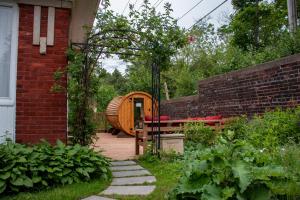 a garden with a wooden barrel next to a brick building at Historic GG Barnum Mansion by Heirloom Boutique Collection in Duluth
