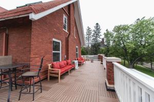 a deck with chairs and tables on a brick building at Historic GG Barnum Mansion by Heirloom Boutique Collection in Duluth