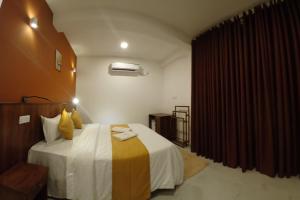 a hotel room with a large bed and a red curtain at Ella Holly House in Ella +19 photos