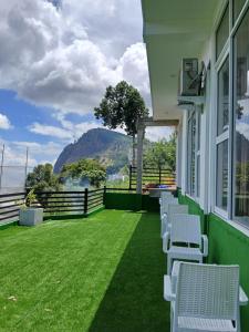 a balcony with chairs and a view of the water at Ella Holly House in Ella