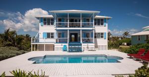 Waterfront Vacation Properties的一座大型白色房子,前面设有一个游泳池