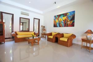 a living room with couches and a painting on the wall at Pondok Ayu in Sanur