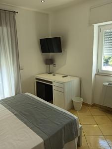 una camera da letto con un letto e una TV a schermo piatto di Flaminio Palace Rooms a Roma