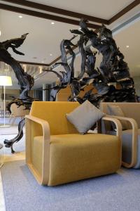 a living room with a couch and a tree mural at Hotel Mas Solà in Santa Coloma de Farners