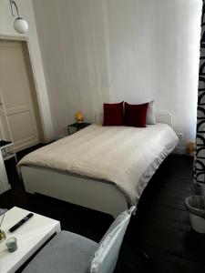 a bedroom with a bed with red pillows on it at Lovely 2 Rooms Next to Sint-Niklaas Very Central in Ghent