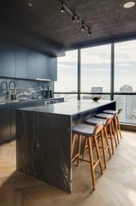 a kitchen with a large black counter and stools at Luxe Lakeview, steps to CN tower & Rogers centre in Mississauga